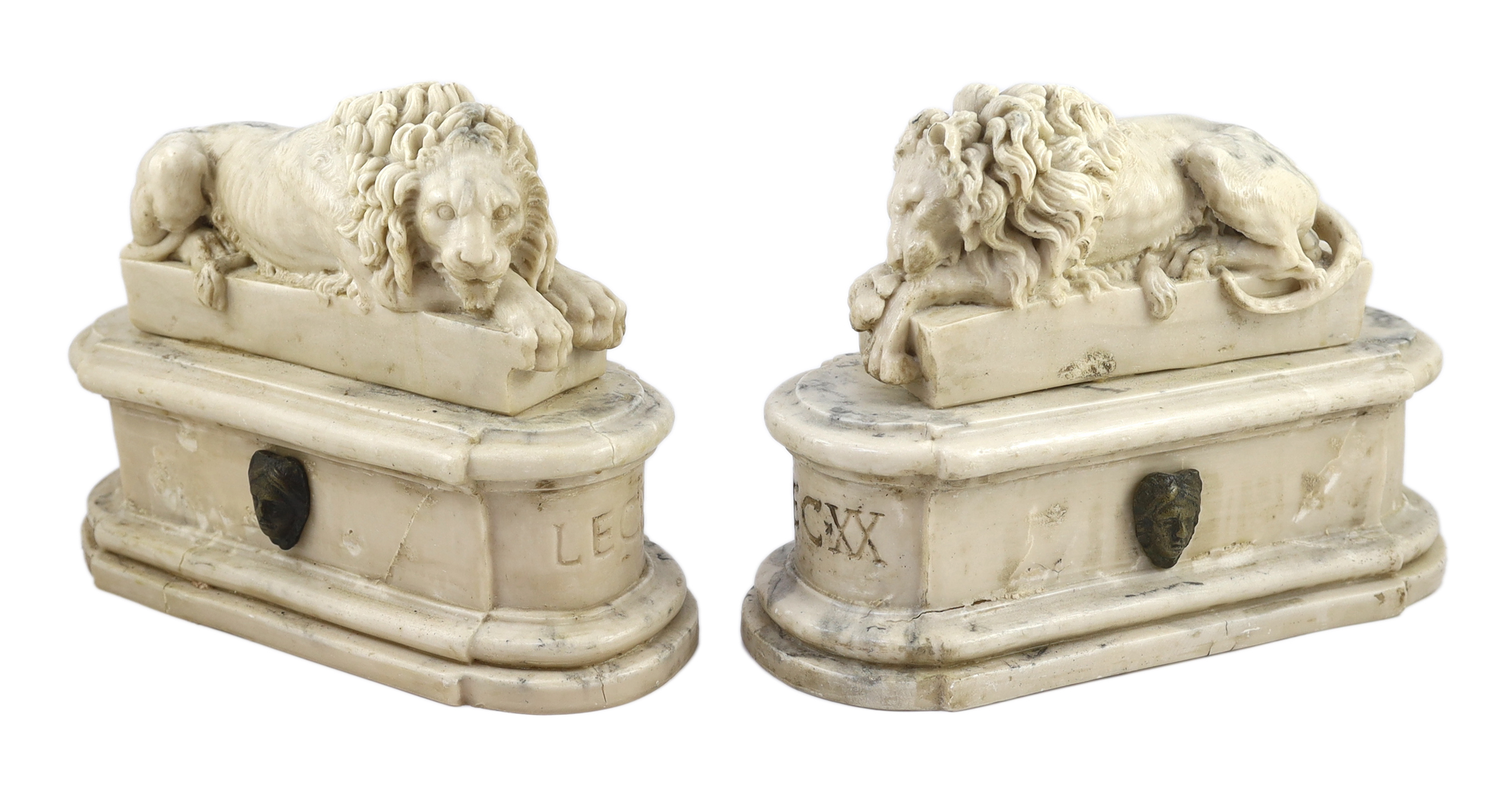 After the Antique. A pair of marble resin models of the Medici lions, each seated upon an oblong plinth, applied with bronze masks, inscribed LECXX, 41cm long, 15cm deep, 29cm high